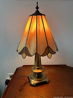 Front side view of the stained glass table desk lamp on a wooden surface with power cord visible.