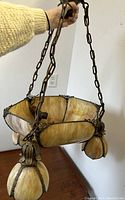 Tiffany era Art Nouveau stained glass hanging ceiling lamp held by chain, shown indoors for scale and detail