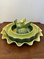 Photo showing whole set stacked with two love birds perched on perforated base, all glazed in green hues