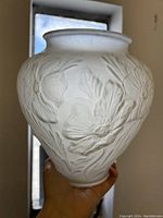 Front side view showing swollen shape and detailed frosted poppy flower design on the glass surface.