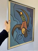 Photo showing the framed indigenous art print held at an angle to display depth and framing