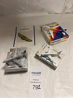 Photo showing several collectible model planes from Air Pacific, ANA, Pan Am, and a Boeing golden wings pin on a card.