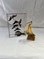 Two vintage art sculptures made from brass and copper on white fabric backdrop.