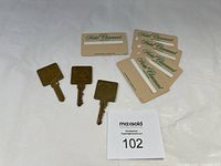 Three brass vintage hotel keys and five plastic Hotel Claremont key cards on a white background.