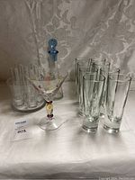 Glassware including decanter, cocktail glass, tall drinking glasses, and ice bucket with shot glasses