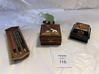 Overview of entire lot showing jade elephant, two wooden boxes, and wooden pen tray with three fountain pens.