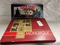 Closed Monopoly Star Wars game box with cover art showing Darth Vader and other characters, box shows signs of light wear.