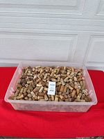Large plastic bin filled with numerous used wine corks.