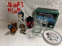 Photo showing the variety of items including a James Dean book, Dodgers bobblehead, plush moose, collectible tin, glass mug, souvenir plate, and lion keychain.