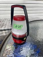 Full view of the red and black Energizer portable lantern with handle, showing the overall condition and size.