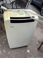 Full view of the Haier portable air conditioner showing the beige body and exhaust hose attached.
