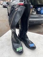 Front side view of the pair of black leather ladies boots showing the zipper and overall exterior condition