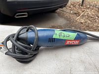 Photo showing side profile of blue Ryobi detail sander with power cord coiled around it, green label with number #212 visible.