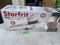 Photo of complete Starfrit Pro Mandoline slicer with grater in original box showing product and branding