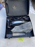 Photo of Wahl hair clipper inside black carrying case with cord, clipper guards, and bubble wrap.