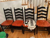 Six Jamco Wood two-tone wooden dining chairs with high ladder backs, black frames, and reddish-brown seats, showing overall condition and design.