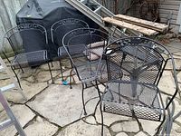 Group of four chairs arranged outdoors on stone patio