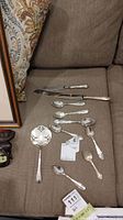 All silver flatware laid out on sofa