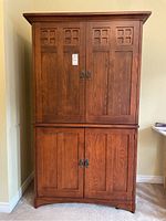 Front view of the hardwood TV cabinet showing door and inlay detail