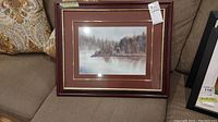 Full view of framed watercolour landscape painting on sofa showing overall condition and framing style.