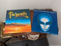 Top-down view showing front album covers: Nazareth Greatest Hits on left, Automatic Man on right.