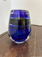 Side view of mid-century modern glass vase showing deep cobalt blue color with clear horizontal bands.