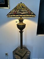 Full view of illuminated lamp showing shade and brass base