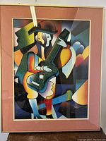 Front view of the framed cubist style oil painting depicting a musician with guitar. Visible artist signature in lower right corner.