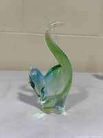 Front side view of the green and blue abstract cat glass figurine on neutral background.