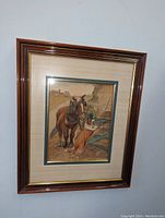 Framed watercolor painting of a brown horse and a collie dog standing at a wooden farm gate in rural setting, signed and dated 1922 bottom right.