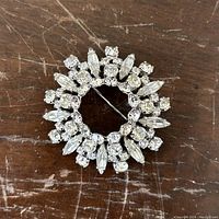 Front view of the circular rhinestone brooch with clear round and marquise-shaped rhinestones on a silver-tone setting.