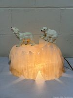 Clear frontal image of the alabaster iceberg lamp with two white polar bears on top. The lamp is lit, showing the alabaster material glowing.