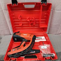 Open red Hilti case showing GX 120 tool, manual, and accessories