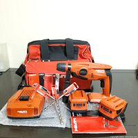 Full kit laid out showing drill, charger, batteries, bits and bag