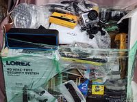 Wrapped box showing Lorex security system packaging, zippered case and action camera