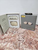 Open box showing charging case, extra ear tips and original retail box