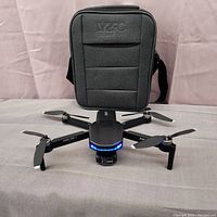 Foldable drone deployed in front of zippered carrying case