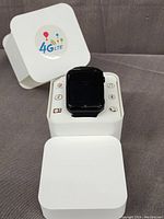Black W5 4G LTE smartwatch displayed on and inside its white packaging box. Box lid featuring 4G LTE logo.