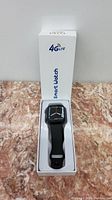Black smart watch displayed in white box with 4G LTE branding
