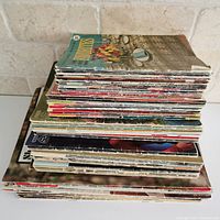 Stack of over 50 assorted vintage pattern books and magazines in a pile viewed from the side