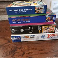 Stacked view of the four puzzle boxes showing titles and piece count.