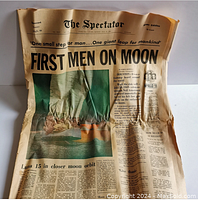 Front page of The Spectator newspaper with large headline 'FIRST MEN ON MOON' with color photo and other articles around it.