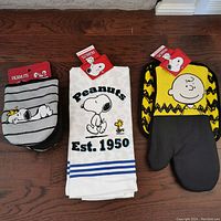 Photo showing the three main textile items: two kitchen hand towels and two oven mitts, all with Peanuts characters.