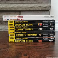 Stack of 11 home improvement books showing titles and color schemes