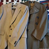 Both the camel hair blazer and wool trench coat displayed side by side on hangers to show condition and fabric detail.
