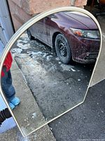 Front view of the large curved top mirror showing the gold and white trim and clear reflective surface.