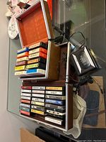 Sony Walkman with attached earphones and large collection of cassette tapes in velvet-lined box