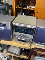 Aiwa mini stereo system with main unit and two speakers on shelf, showing overall setup