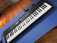 Full length view of black Casiotone CT-S195 keyboard showing keys, control panel, power cord, and brand logo.