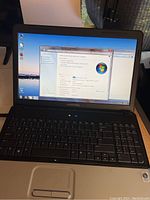 Open Compaq laptop showing Windows 7 desktop screen.